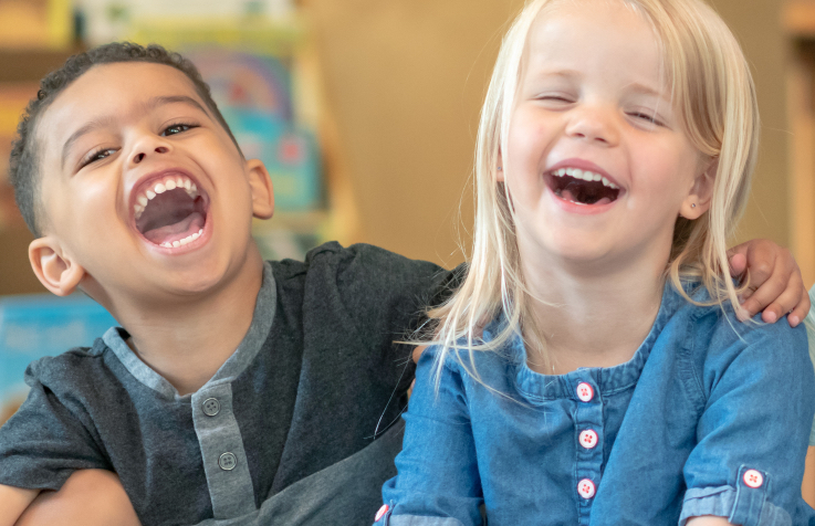 photo of two preschoolers laughing together